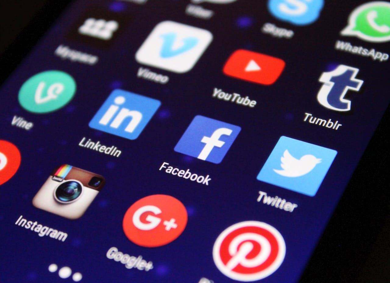 team-02 Close-up of a smartphone screen showing various social media app icons such as Facebook and Twitter.