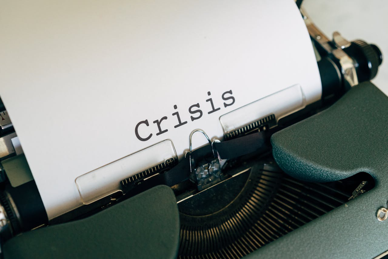 services-04 Close-up of a vintage typewriter with the word 'Crisis' typed on paper.