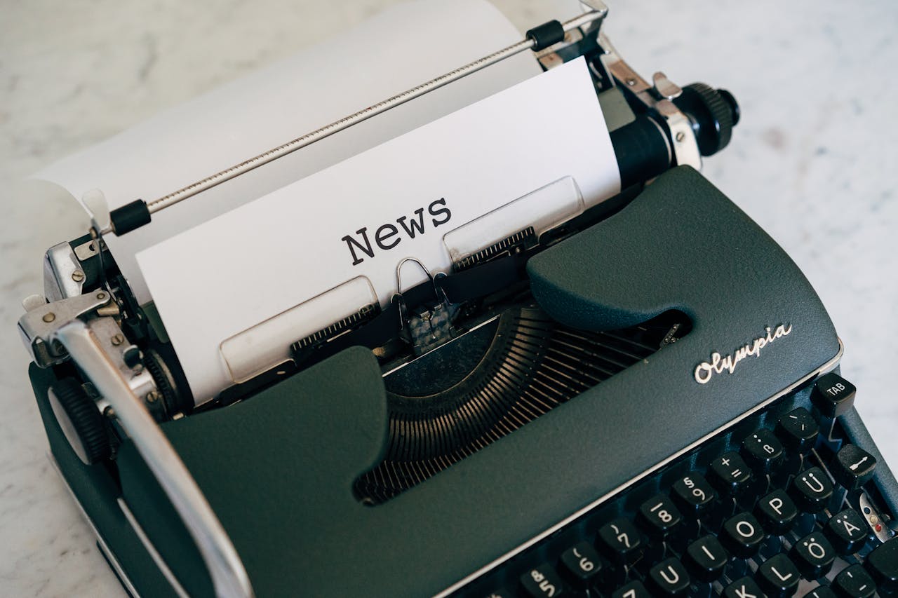 team-01 Close-up of an antique typewriter with 'News' on paper.